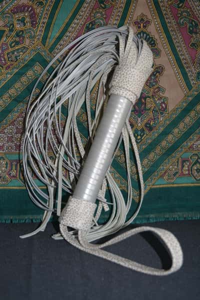 A completely handmade whip made of white leather.